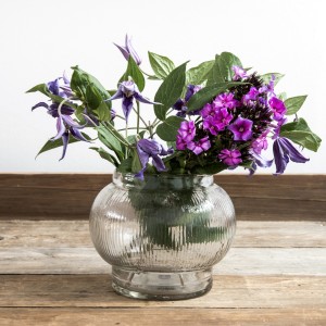 Vase of bright flowers against a wooden table