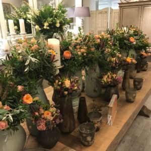 Long wooden table with green vases filled with pink roses