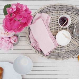 Breakfast table with pink flowers jam and croissants