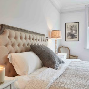 Neutral bedroom with bed and candle