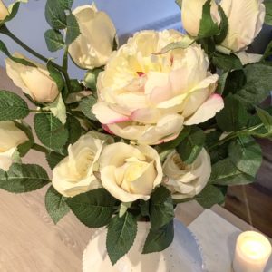 Large white faux flowers in jug