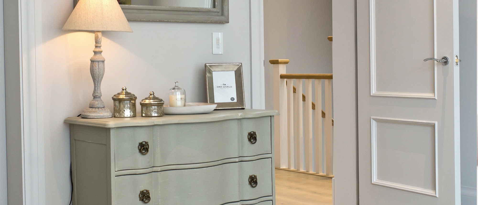 Light green chest of drawers with table lamp