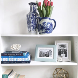 Open white shelves with decorative coral and ceramic blue vase