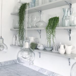 Open kitchen shelving with glass vases and ceramic jugs