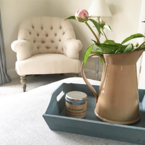 Upholstered chair and flowers in jug