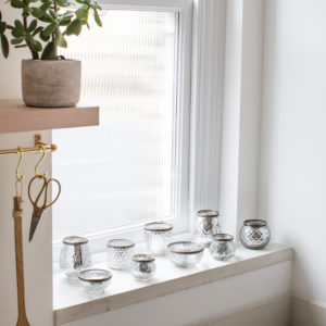 Silver tea light holders on shelf 