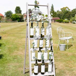 Table plan ladder with wine bottles and foliage 